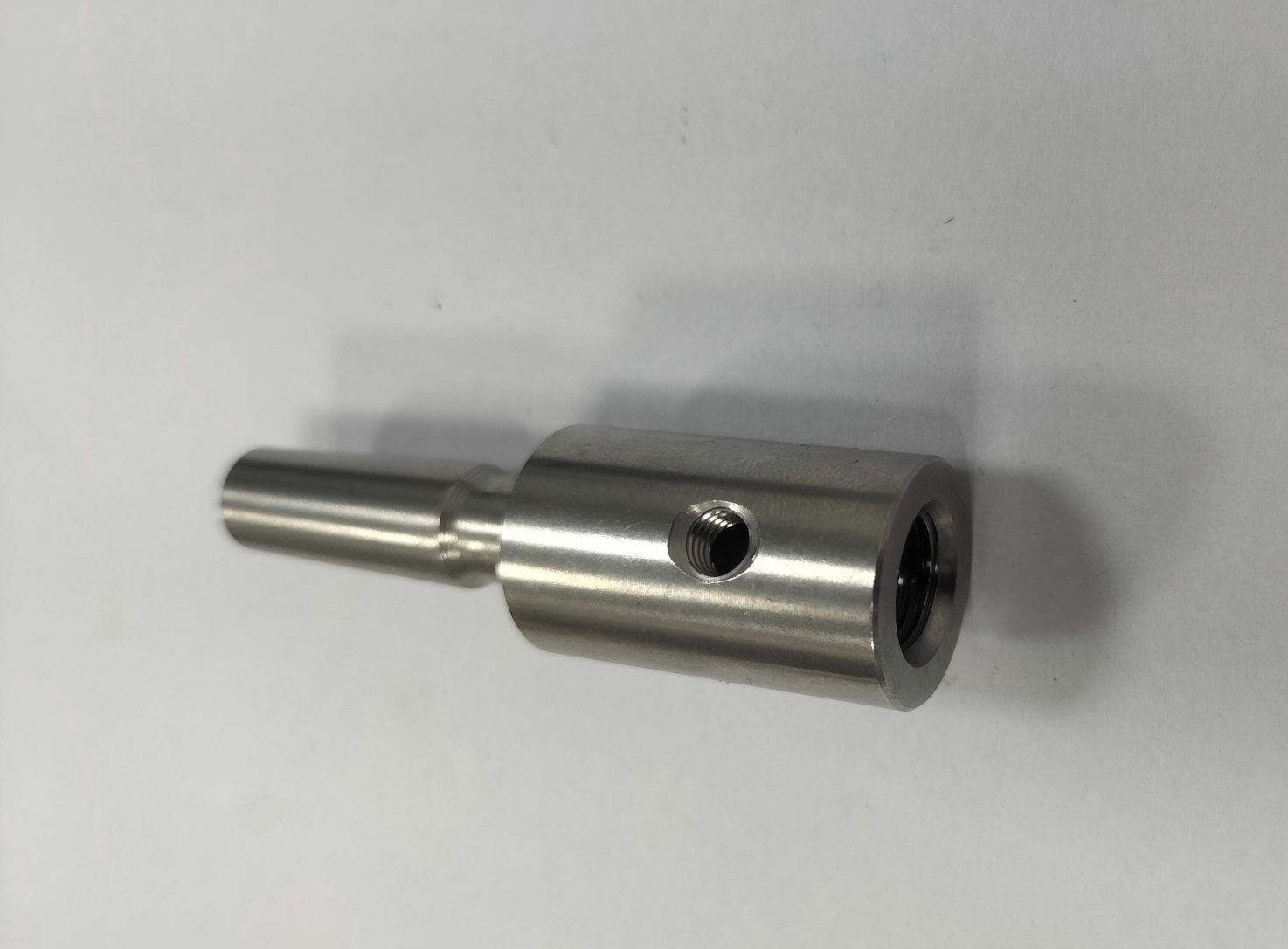 Stainless steel connector component for electrical or fluid systems, showcasing precision CNC milling and turning.
